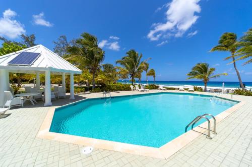 a swimming pool with a gazebo and the ocean at On The Bay in North Side