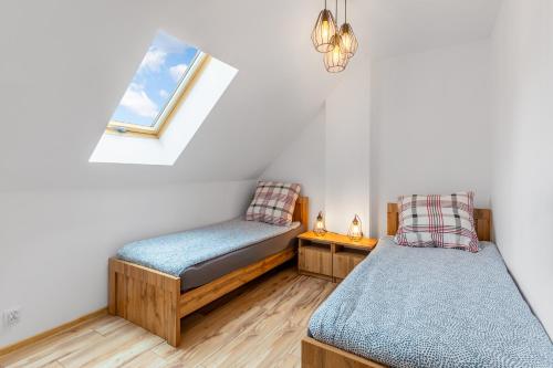 a room with two beds and a window at Domki Niedźwiadki nad morzem in Kopalino