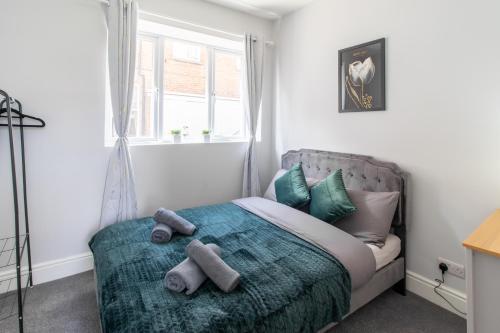 a bedroom with a bed with two stuffed animals on it at Open Mind Property - Cosy Apartment with 3 Beds in Portsmouth