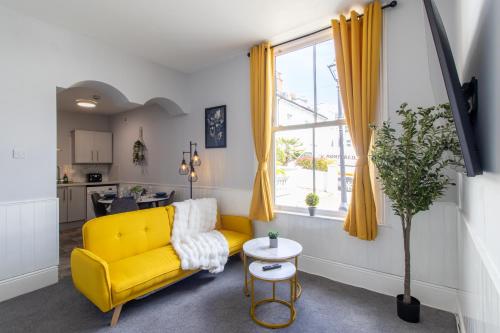 a living room with a yellow couch and a window at Open Mind Property - Cosy Apartment with 3 Beds in Portsmouth