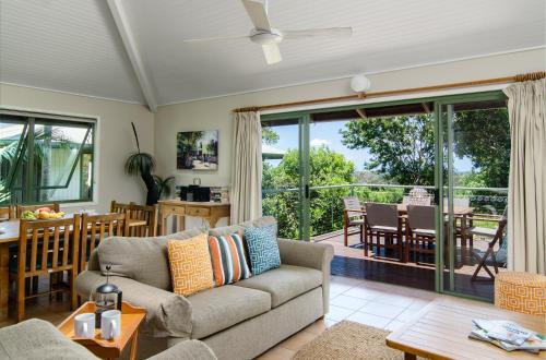 a living room with a couch and a table at The Retreat Beach Houses in Peregian Beach