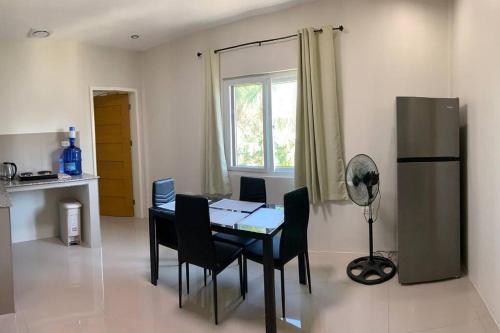 a dining room with a table and chairs and a window at Zagill Moalboal in Moalboal