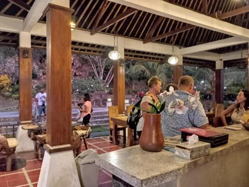 a group of people sitting at a table in a restaurant at Cersen Resort Lombok in Kuta Lombok