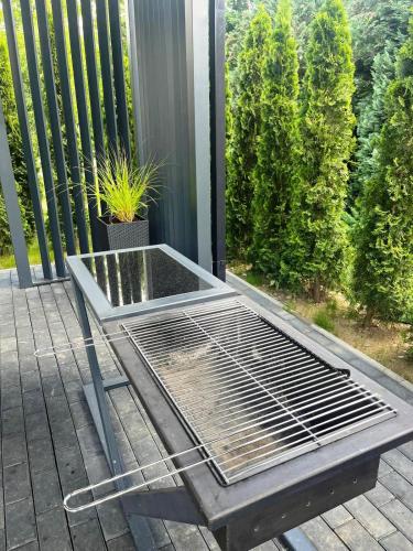 a grill on a porch with a plant on it at Domki Cztery Pory Roku in Czchów
