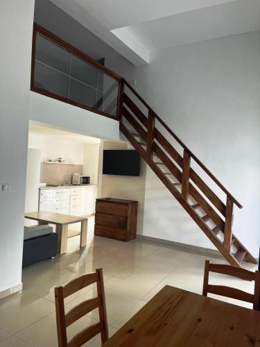 a staircase in a room with a table and a kitchen at Domki Cztery Pory Roku in Czchów
