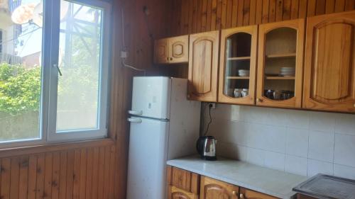 a kitchen with a white refrigerator and a window at Holiday Cottage in Ureki, Georgia in Ureki