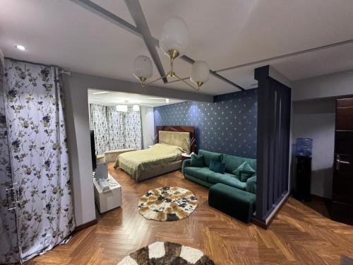 a living room with a green couch and a bed at Mountain View Hyde park luxury villa in New cairo