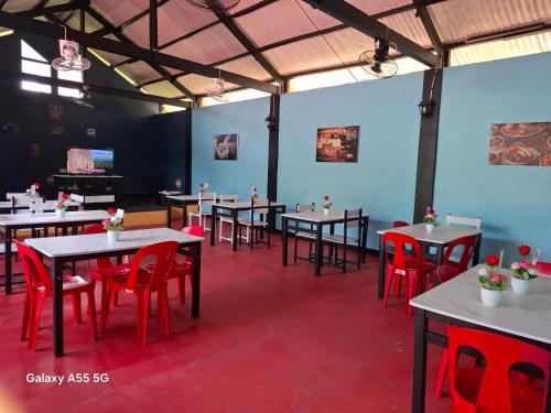 a dining room with tables and red chairs at Rose Guest House in Canhangdon