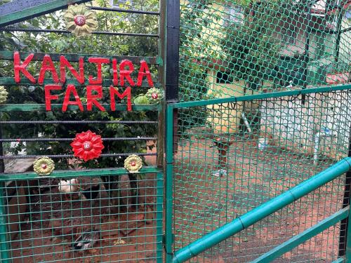 a dog in a cage with a sign that says karma farm at Kanjira house in Ooty