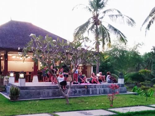 a group of people doing yoga in a garden at Cersen Resort Lombok in Kuta Lombok