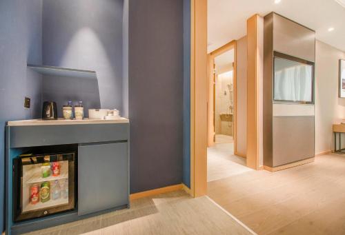 a living room with a fireplace and a hallway at Atour Hotel Guangzhou Sanyuanli-Guangzhou Baiyun Railway-Fiee Self-Service Laundry in Guangzhou