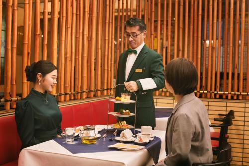 a man and woman sitting at a table eating food at Hotel Continental Fuchu in Fuchu