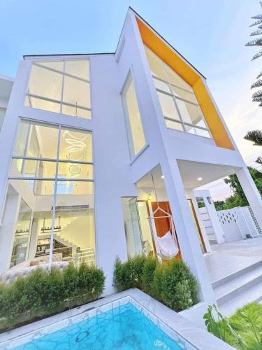 a house with a swimming pool in front of it at Luxury Pool Villa 99 in Ban Bang Krang