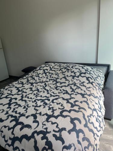 - un lit avec une couette en noir et blanc dans l'établissement Charmant studio à 5 min de la mer, à Cagnes-sur-Mer