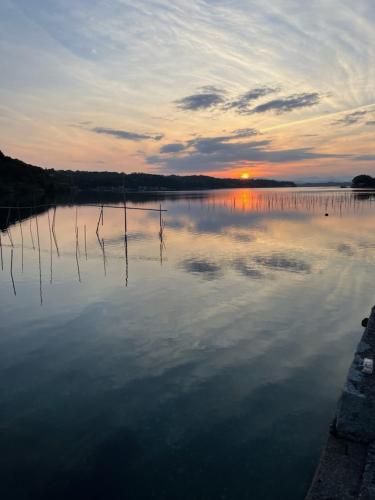 a large body of water with the sunset in the background at Yadokari Shima in Shima