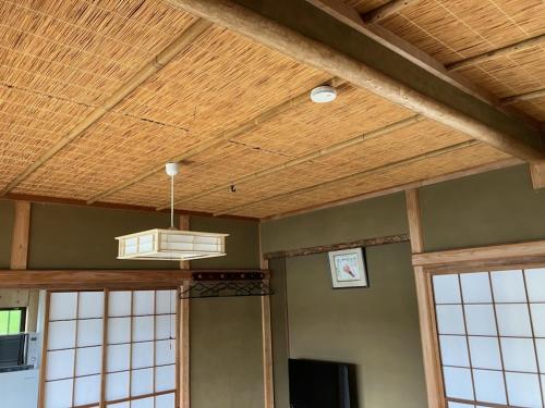 a room with a wooden ceiling with a light at Yadokari Shima in Shima