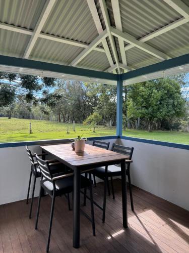 a table and chairs on a porch with a view of a field at Farm stay on the river in Langley Vale