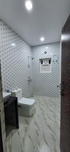 a bathroom with a toilet and a sink at New Sun International & Banquet Hall in Jamshedpur