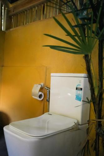 a white toilet in a bathroom with a palm tree at Villa Hillcrest in Weligama