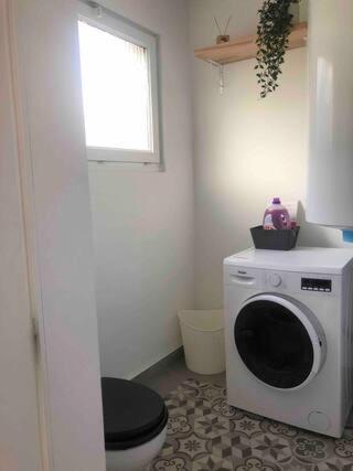 a bathroom with a toilet and a washing machine at Maison de ville paisible in Lormont