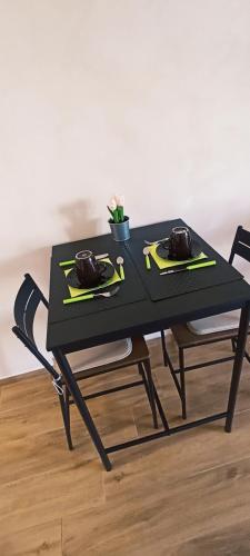 a black table with two chairs and a black table with a plant at Regina di Puglia in Santeramo in Colle