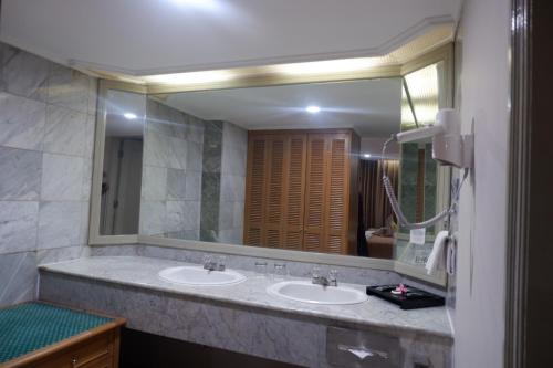 a bathroom with two sinks and a large mirror at Horison Ultima Bandung in Bandung