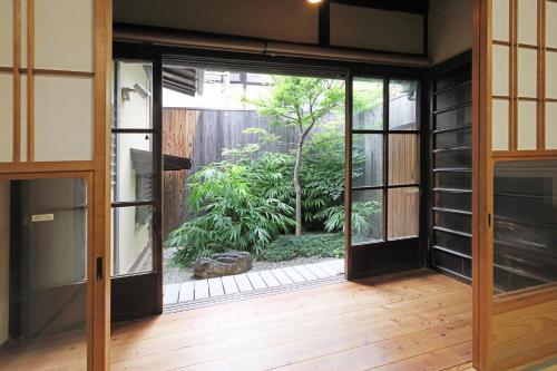 an open door with a view of a garden at Heiankyu-dairi no yado in Kyoto