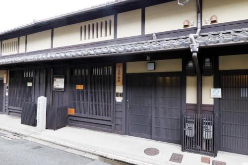 a building with black doors on a street at Heiankyu-dairi no yado in Kyoto