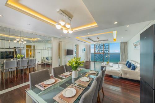a dining room and living room with a table and chairs at Mandila Beach Hotel Danang in Da Nang
