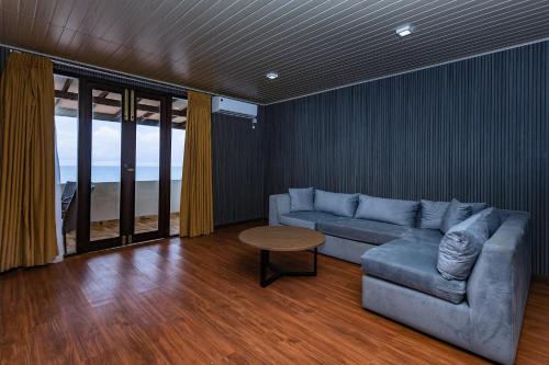 a living room with a couch and a table at Beach & Bliss Mirissa in Mirissa