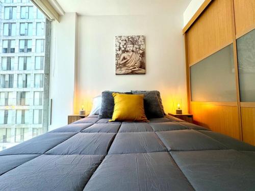 a bedroom with a large bed with a yellow pillow at Centro Histórico Flat in Mexico City