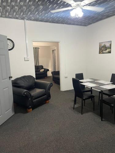 a living room with a table and a couch and chairs at Breeze Manor in Scarborough