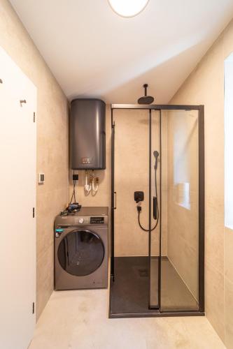 a bathroom with a shower and a washing machine at CASTLE apartments - City Center in Spišské Podhradie