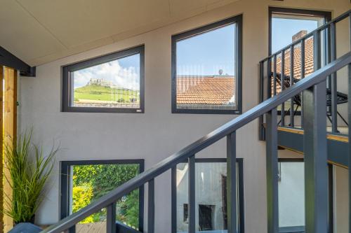 a room with four windows and a staircase at CASTLE apartments - City Center in Spišské Podhradie
