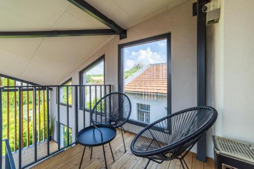 two chairs sitting on a balcony with windows at CASTLE apartments - City Center in Spišské Podhradie