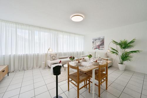 a white living room with a table and a couch at Stylish and Modern 2-Room Apartment in Wuppertal City Center in Wuppertal