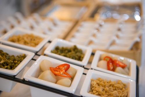 a display case filled with white dishes filled with food at Atour Hotel Guangzhou Sanyuanli-Guangzhou Baiyun Railway-Fiee Self-Service Laundry in Guangzhou