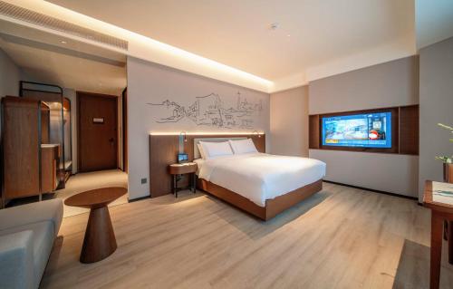 a hotel room with a bed and a tv at UrCove By HYATT Chengdu Wenshu Monastery in Chengdu