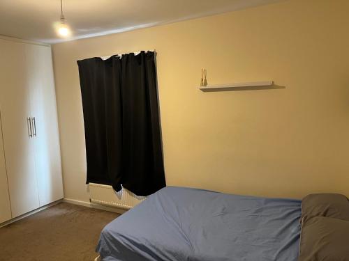 a bedroom with a bed and a black curtain at Jakes holiday inn in Stockton-on-Tees