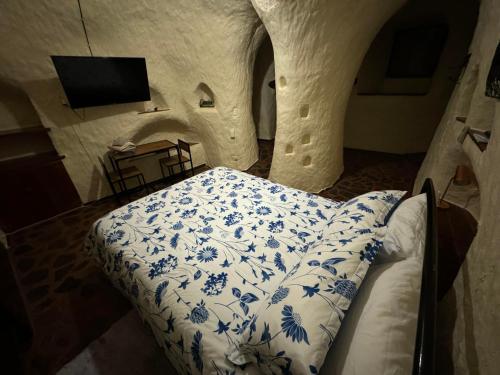 a bedroom with a bed with blue and white sheets at Di's Dugouts in Coober Pedy