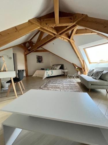 un salon avec une table blanche dans un grenier dans l'établissement Villaveyron, à Roussennac