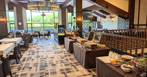 a restaurant with tables and chairs and a large window at Villa the Club Karuizawa in Naganohara