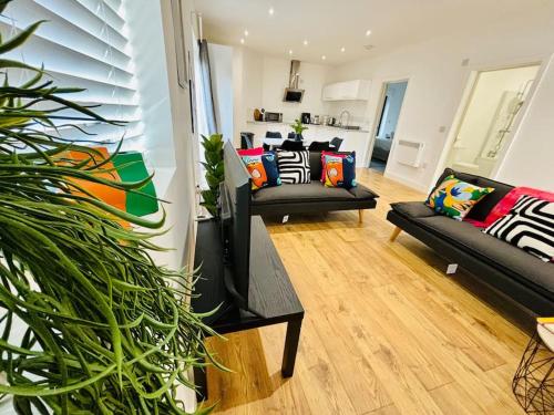 a living room with two couches and a flat screen tv at GL1 City Center & Docks - Parking - Sleeps up 6 ppl - Outside Space in Gloucestershire