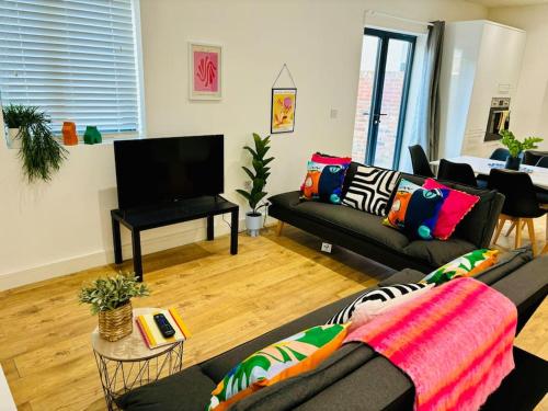 a living room with two couches and a flat screen tv at GL1 City Center & Docks - Parking - Sleeps up 6 ppl - Outside Space in Gloucestershire