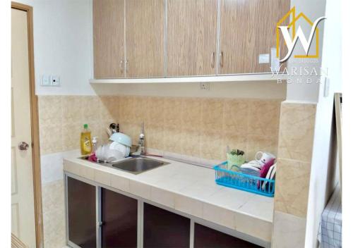 a kitchen with a sink and a counter top at Warisan Bonda Homestay, KTC Kota Bharu in Kota Bharu