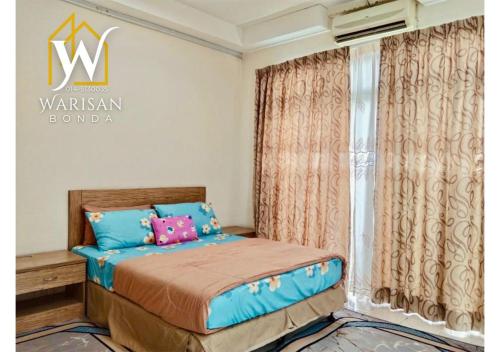 a bedroom with a bed with blue and pink pillows at Warisan Bonda Homestay, KTC Kota Bharu in Kota Bharu