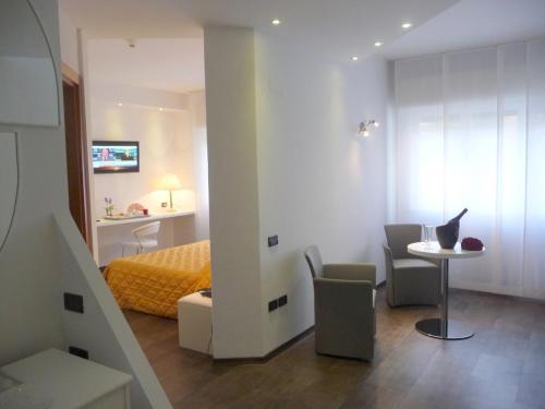 a room with a bed and a table and chairs at Hotel Cristallo in Udine