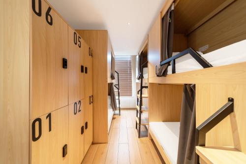 a small room with wooden walls and bunk beds at Captain 5 Youth Hotel-Xianxia Road Branch in Shanghai