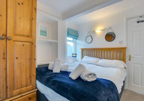 a bedroom with a bed with a wooden headboard at 1 Copper Kettle Apartment in St Ives