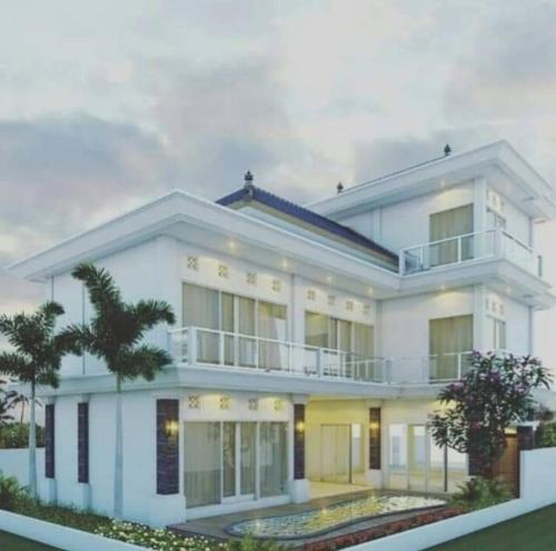 a large white house with a balcony at Villa Emas Mulia Uluwatu Standard 3 in Uluwatu